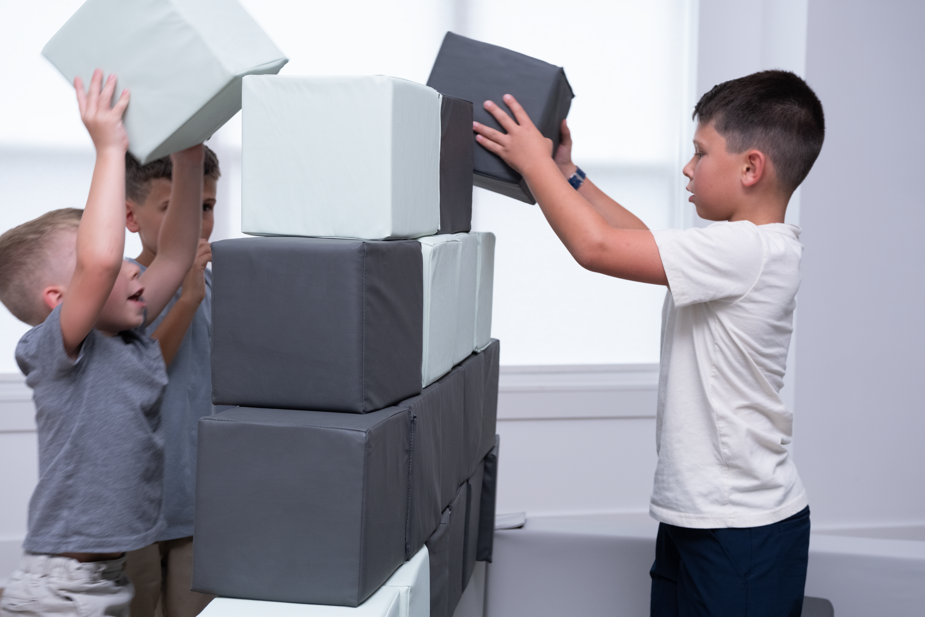 Children playing with foam blocks in a room.