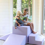 Lifestyle photo of a girl and a boy reading a book while sitting on a lavender gymnasium by Foamnasium