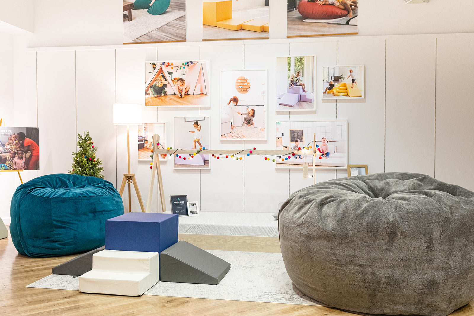 Two Haven bean bags, one teal and one gray, in a room with a wall displaying various photos and decorations.
