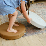 Child playing with  Foamnasium roundabout cushions on a wooden floor