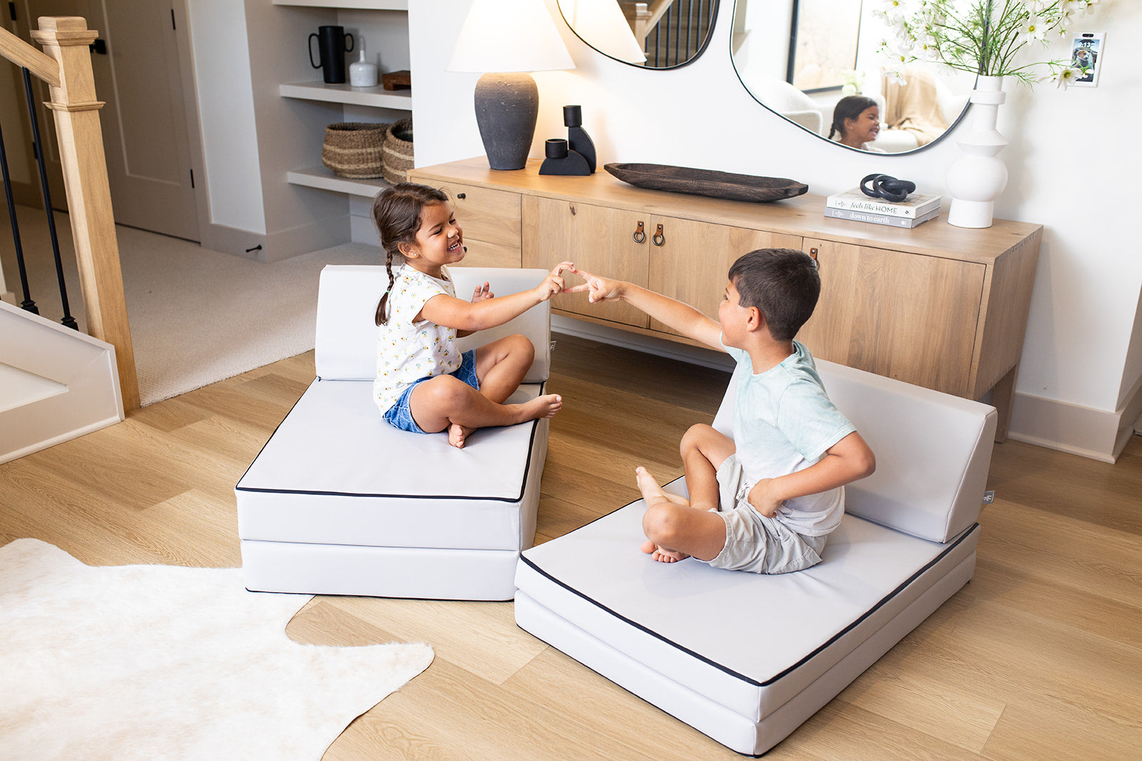 White/cream modular sofa sections arranged in a living room setup, seating for two with side storage and trim details.