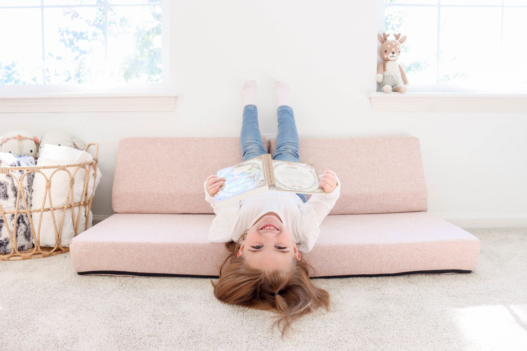 Lifestyle photo of a girl reading a book sitting on a blocksy mini in basketweave blush