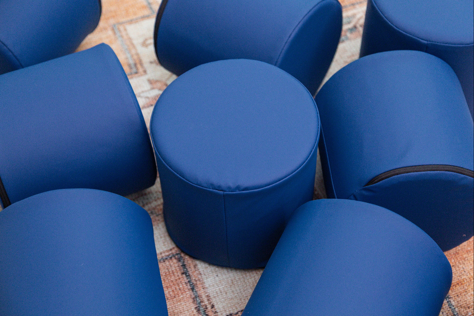 Pile of Navy Foamnasium Cylinders on a rug in a living room