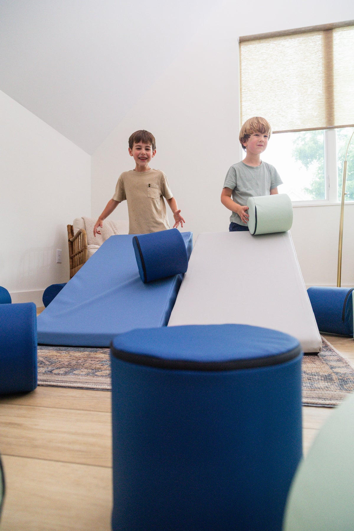 Two boys rolling Foamnasium Cylinders down Mega Wedges