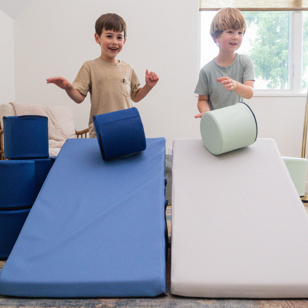 Two kids rolling Foamnasium cylinders down a two mega wedges