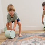 Two kids rolling Foamnasium Cylinders in living room