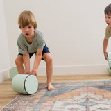 Two kids rolling Foamnasium Cylinders in living room