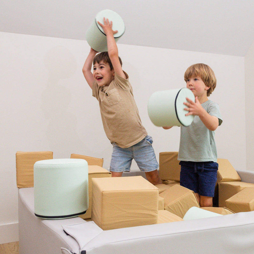 kids throwing foamnasium cylinders in a foam pit