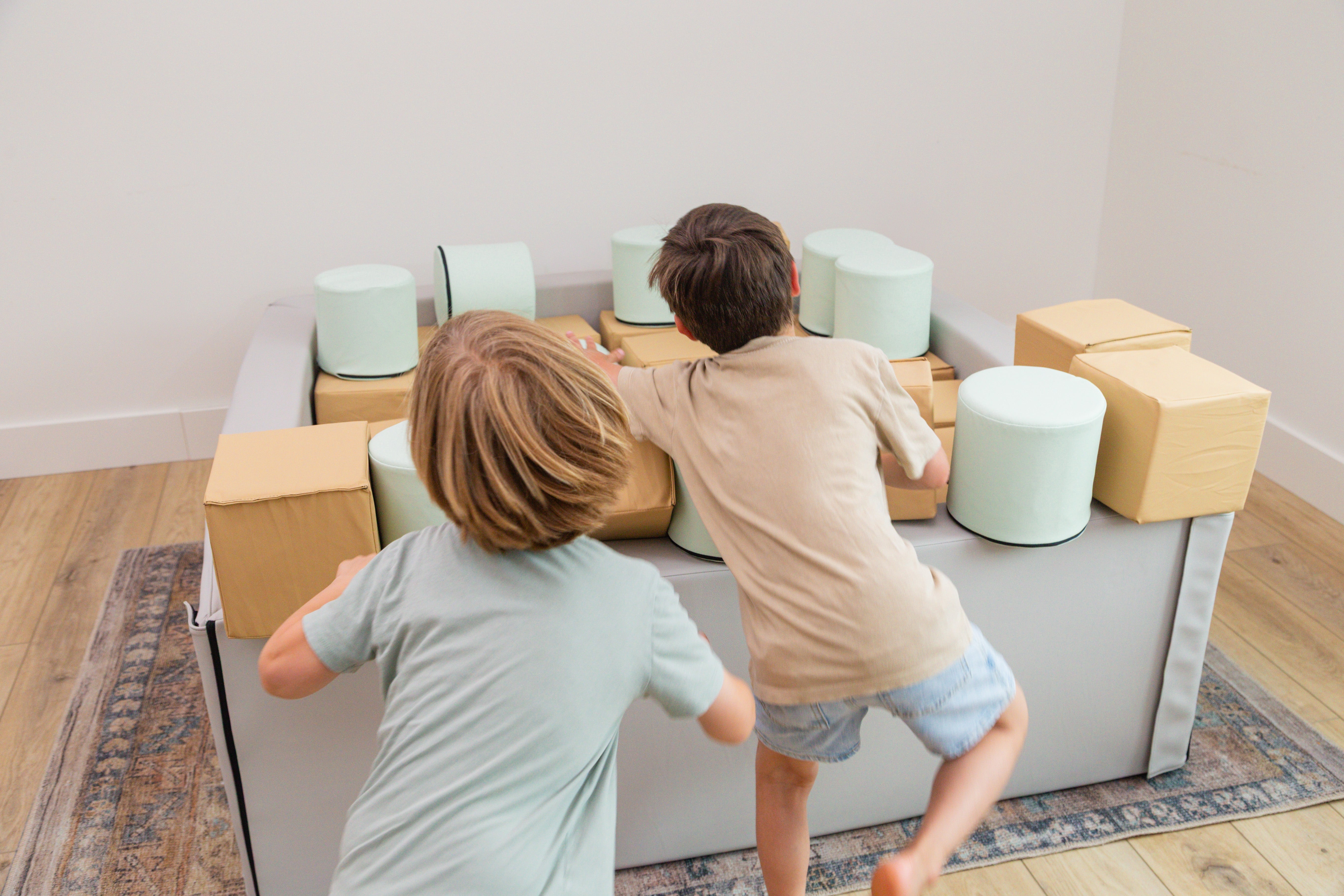 Two boys jumping into the Foamnasium Foam Pit