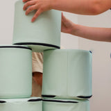 A older child stacking Foamnasium Cylinders in a living room