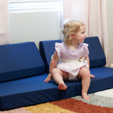 Toddler sitting on Foamnasium Blocksy Mini in Navy in a playroom
