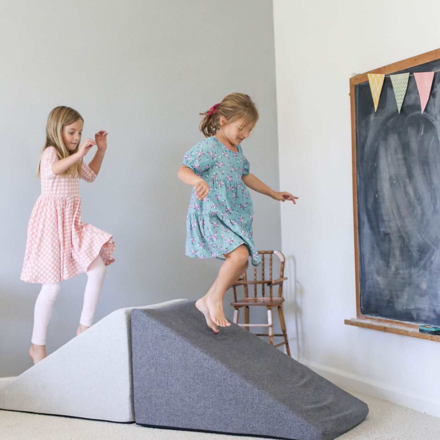 Lifestyle photo of two girls playing on Basketweave Mega Wedges by Foamnasium and Pottery Barn