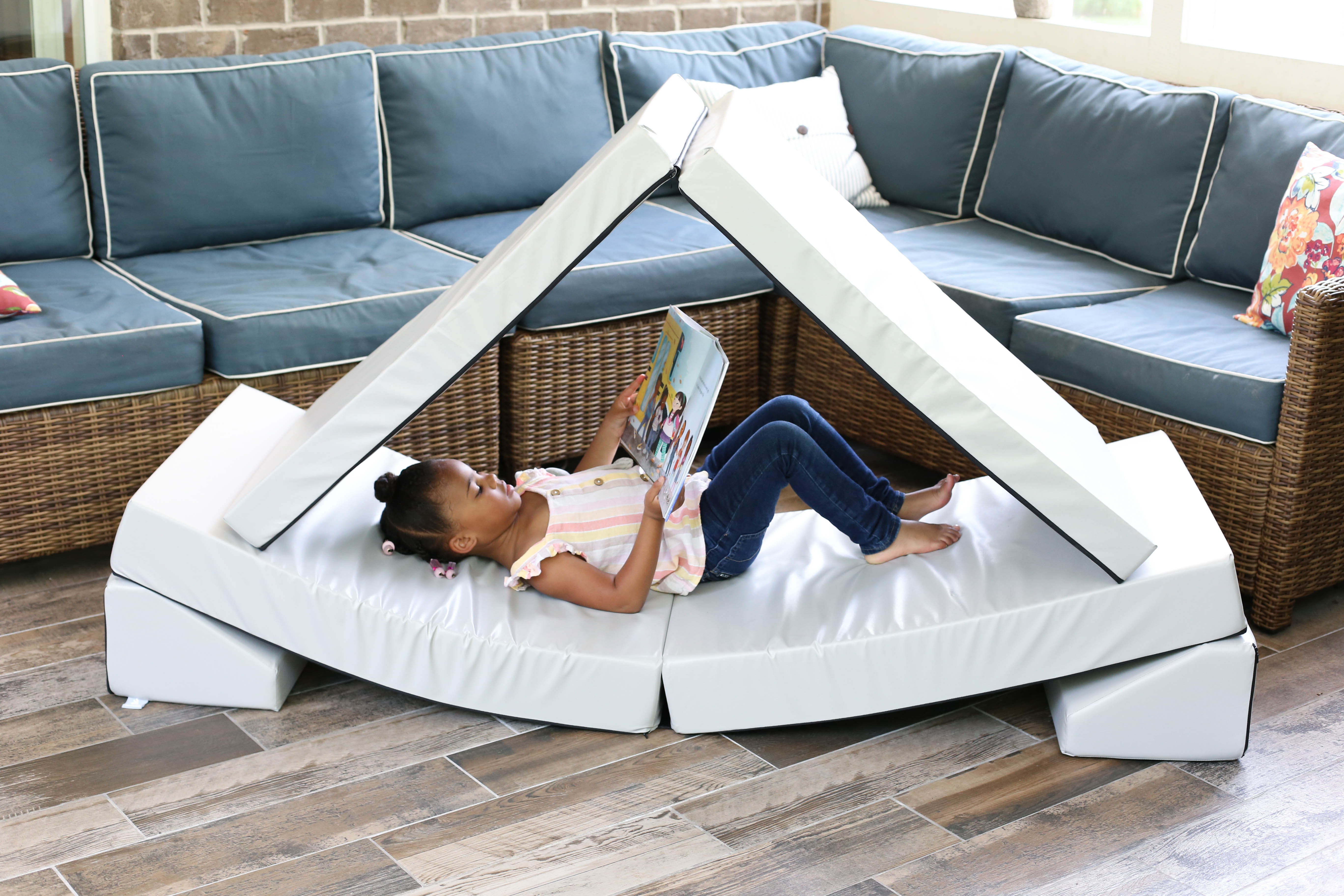 A lifestyle photo of a girl sitting in a blocksy reading