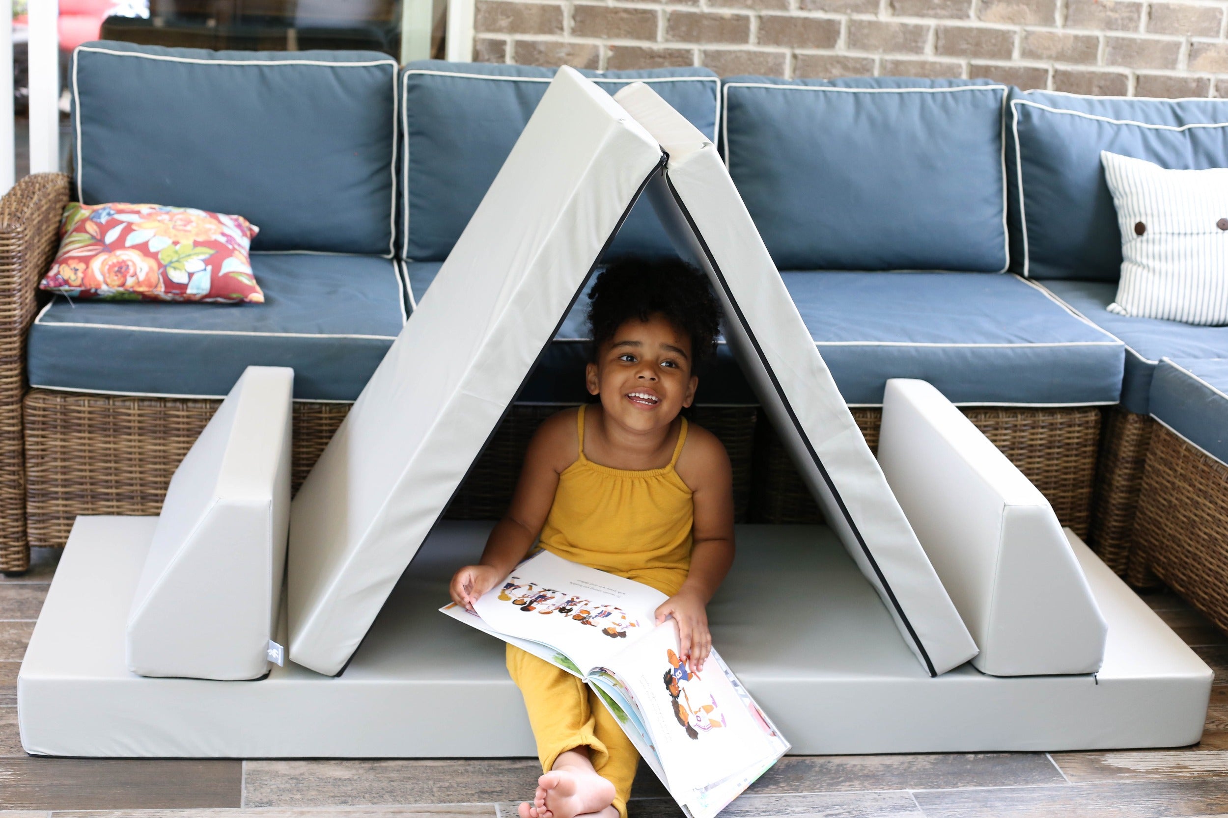 A photo of a girl sitting in a Gull Gray Blocksy set up as a tent