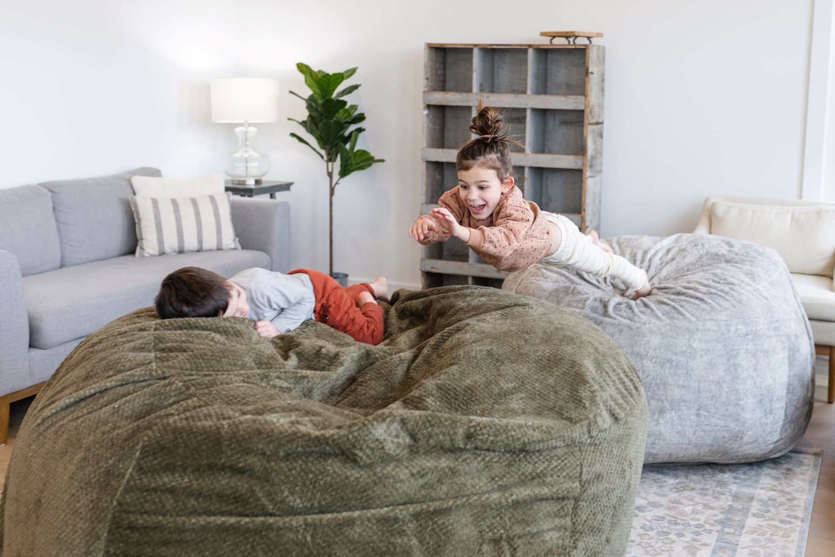 A lifestyle photo of two kids jumping in a large Sage Haven bean bag by Comfort Option