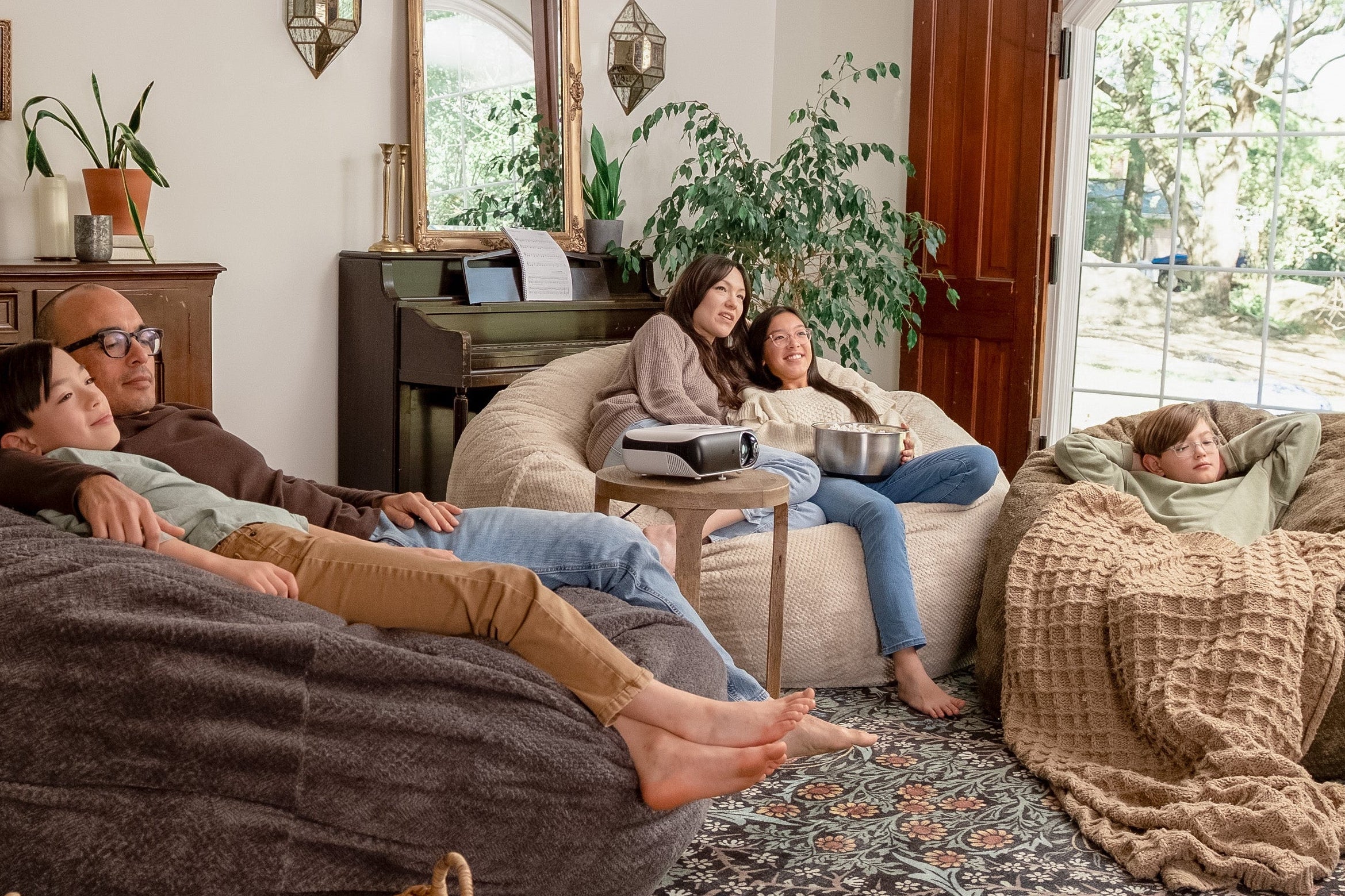 People relaxing on Haven bean bags in a cozy living room with plants and decor.