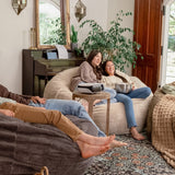 People relaxing on Haven bean bags in a cozy living room with plants and decor.