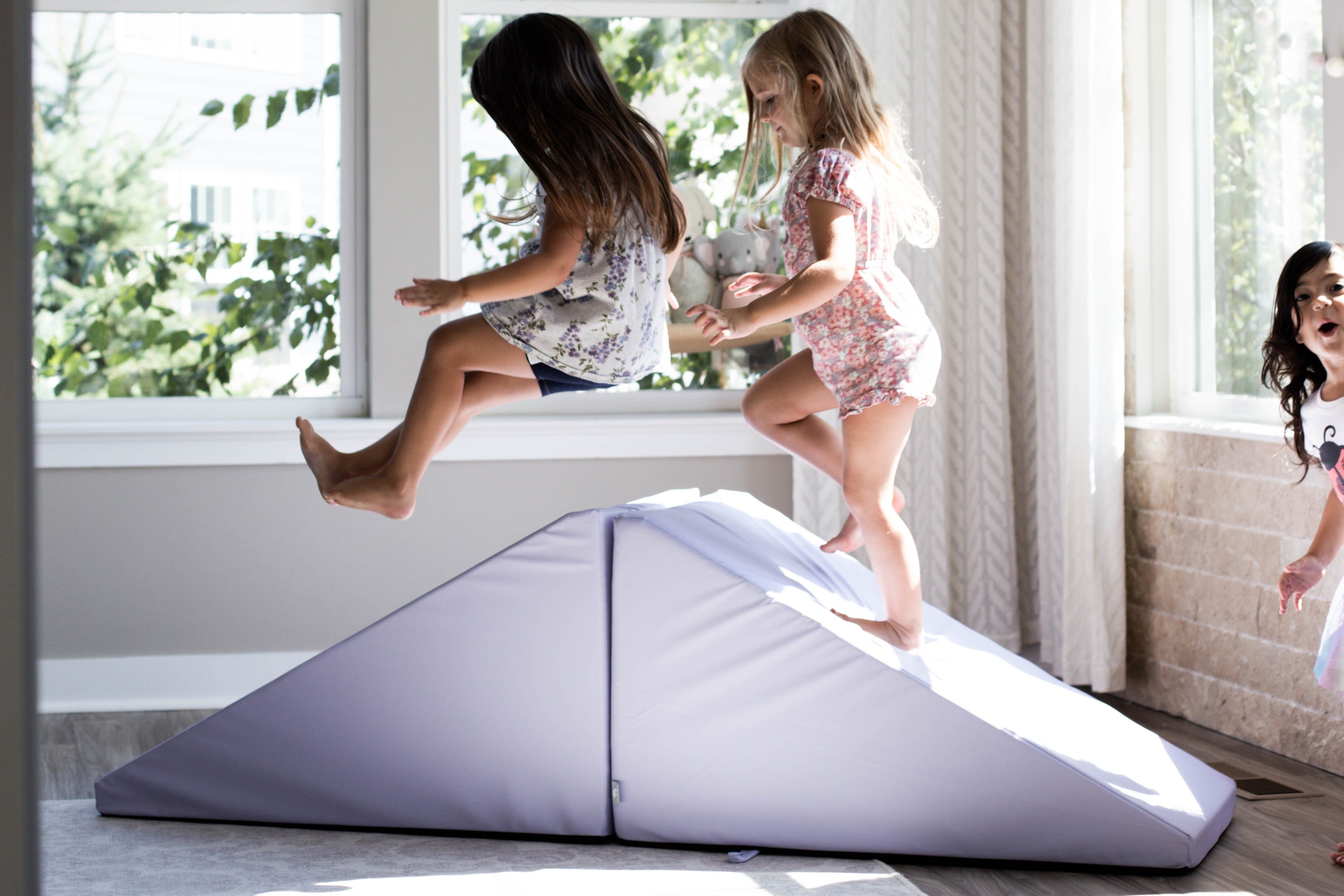 Lifestyle photo of three girls playing on an Enhanced Lavender Foamnasium Mega Wedges Set