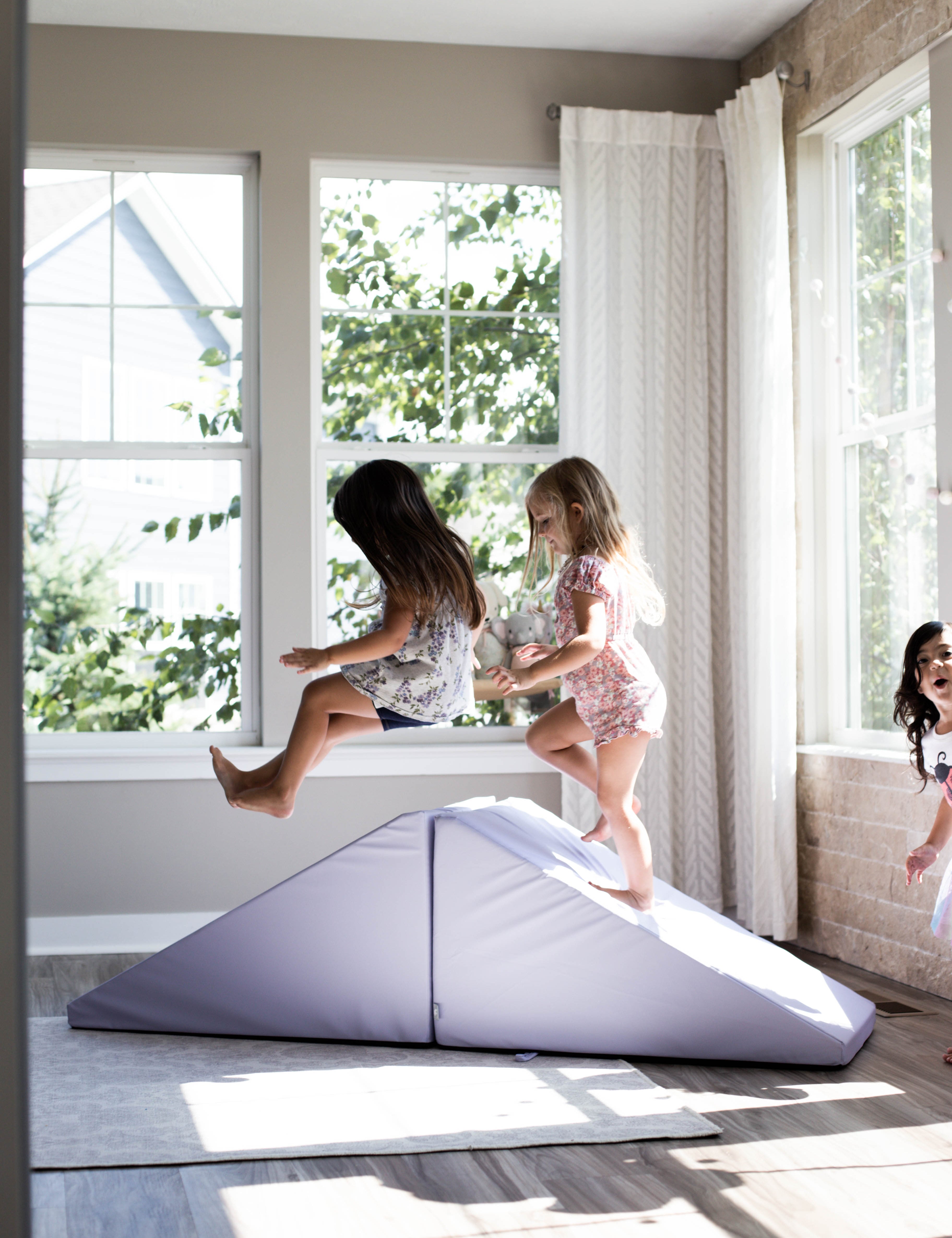 Lifestyle photo of three girls playing on an Enhanced Lavender Foamnasium Mega Wedges Set