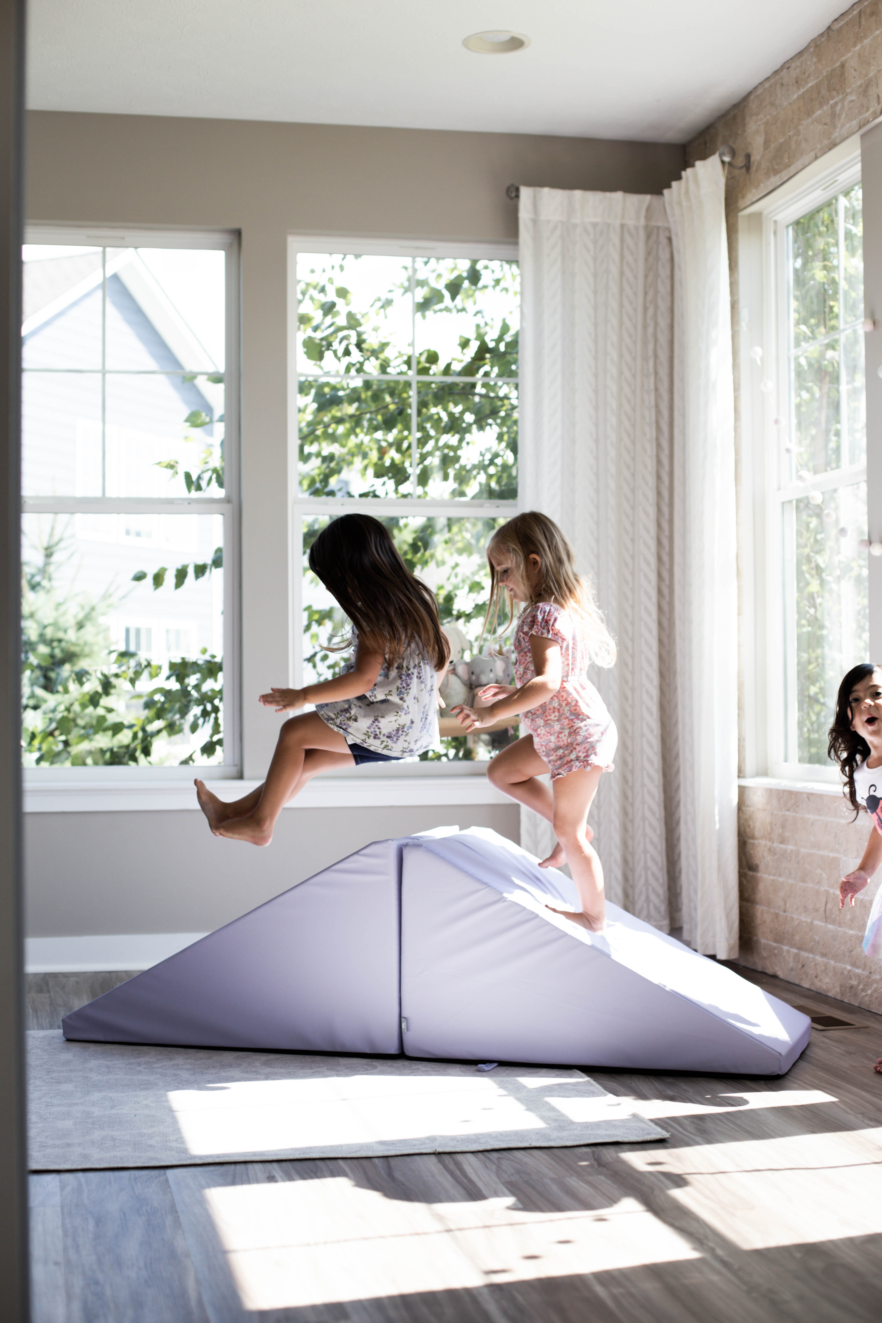 Lifestyle photo of three girls playing on an Enhanced Lavender Foamnasium Mega Wedges Set