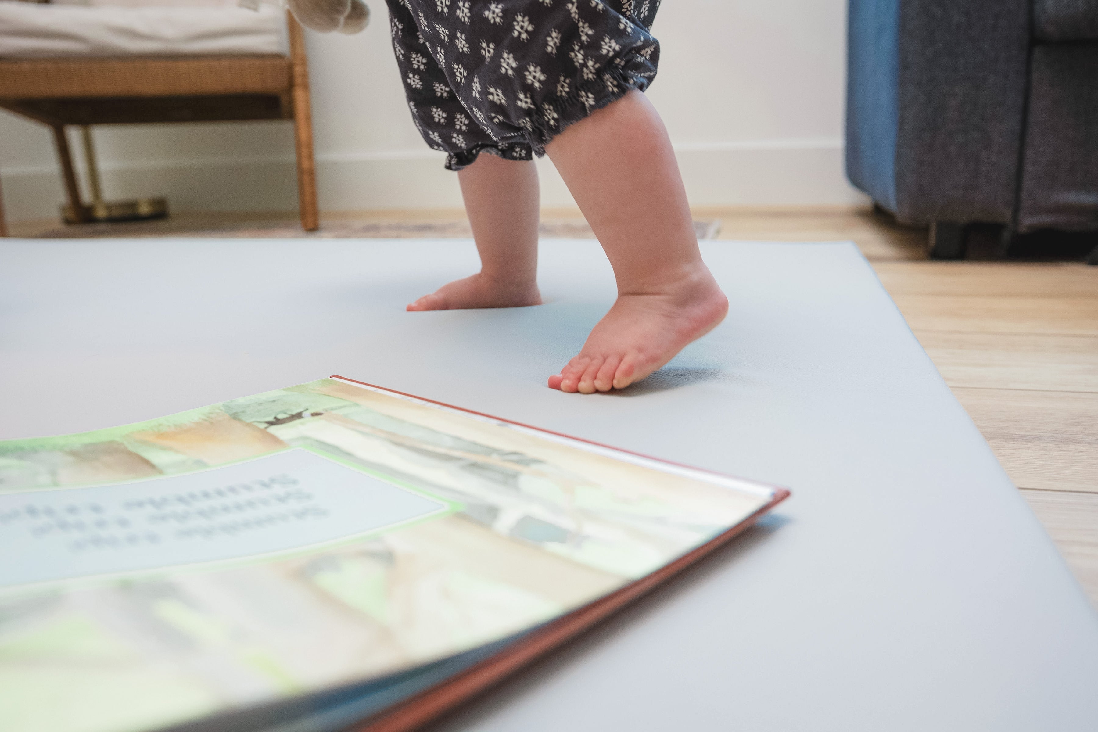 Child's feet standing on a yoga mat with a book open in front
