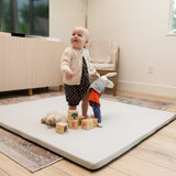 A little kid playing with toys on a Foamnasium mat