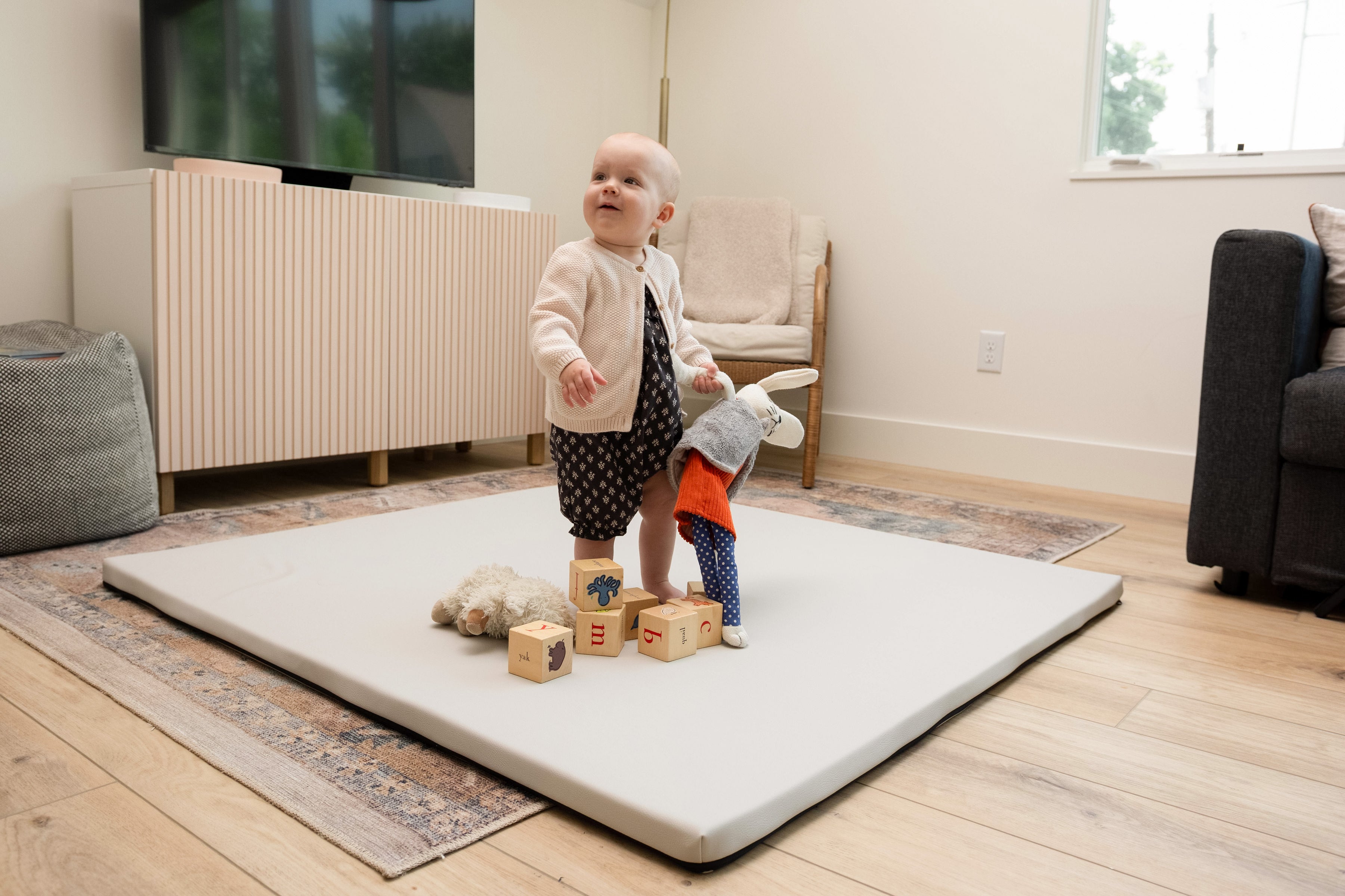A little kid playing with toys on a Foamnasium mat