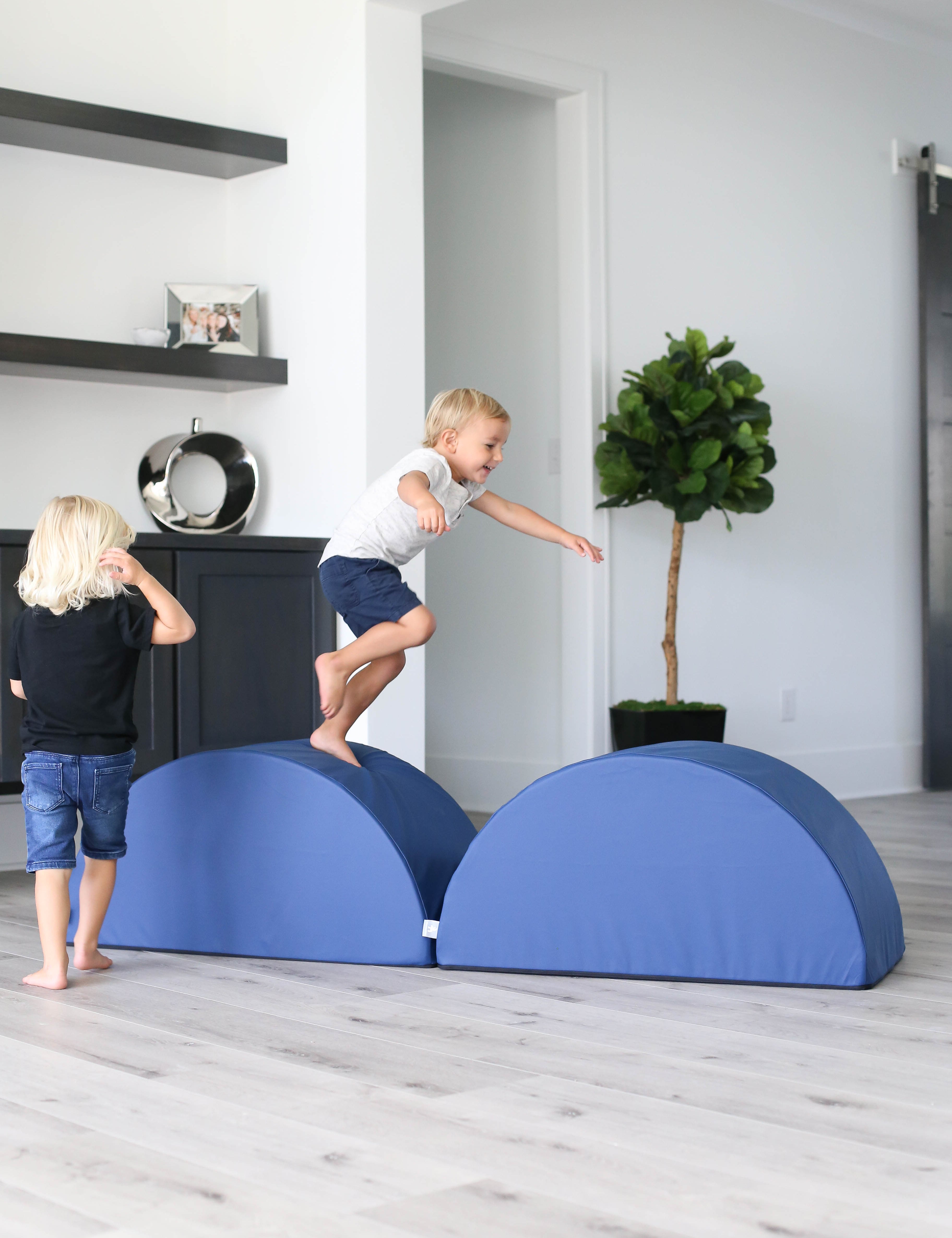 Lifestyle photo of two boys jumping on navy tumblers