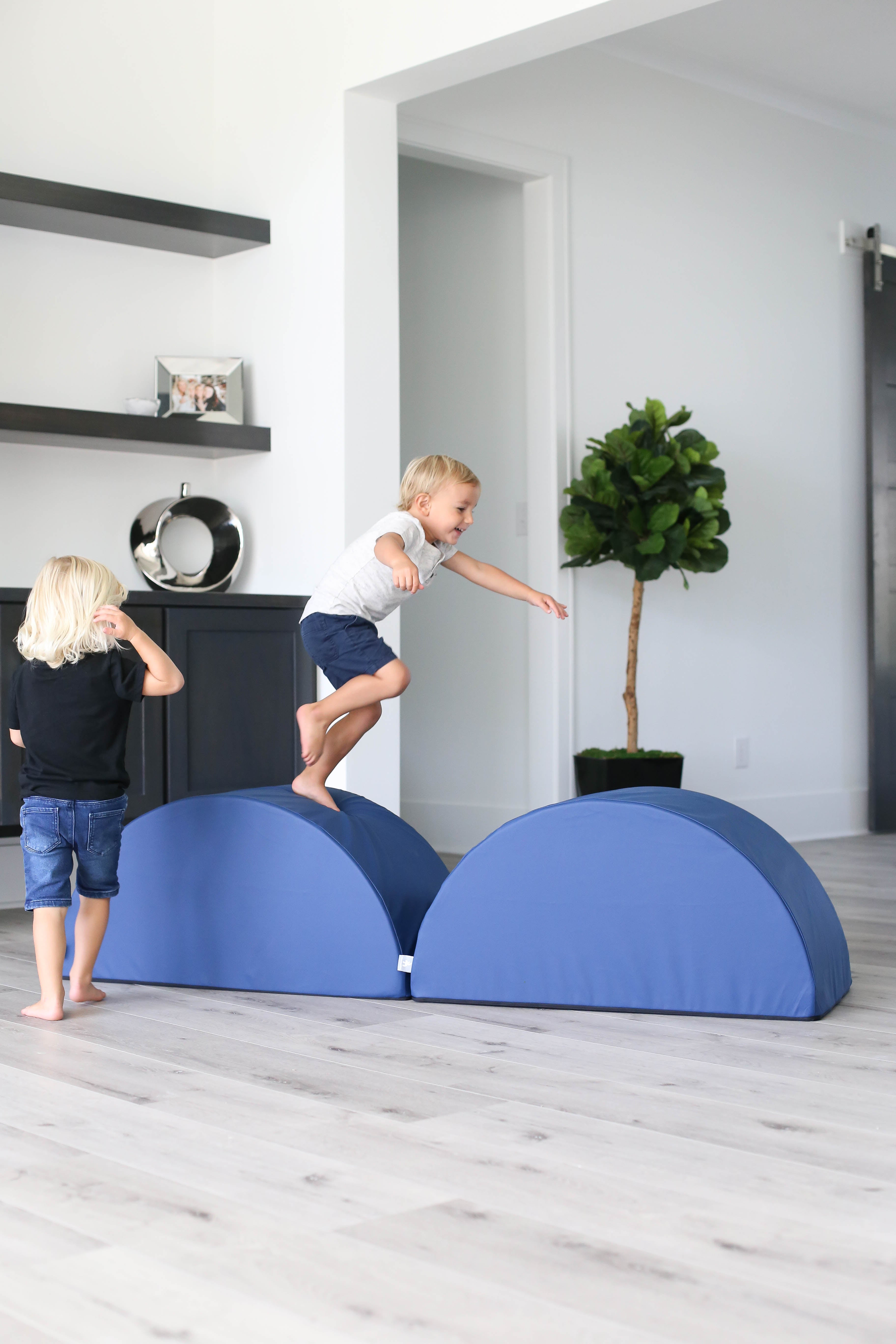 Lifestyle photo of two boys jumping on navy tumblers